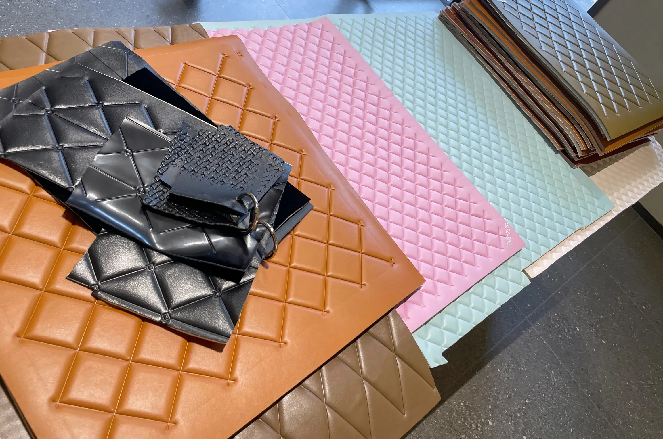 Leather and alternative material swatches reviewed for handbag development