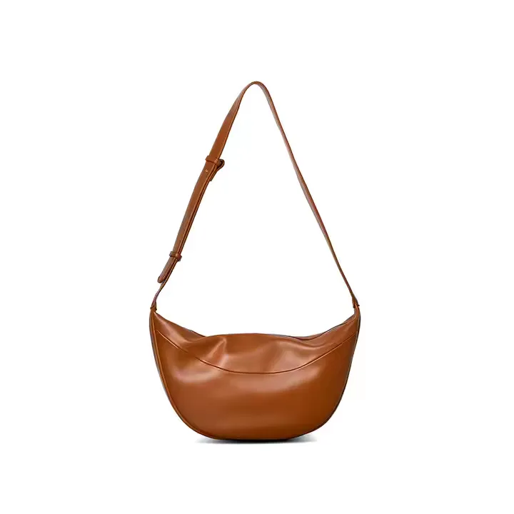 A sleek custom crossbody bag in rich brown leather featuring a rounded, crescent shape with an adjustable strap. The bag has a clean, modern design, perfect for hands-free wear and everyday minimalism.