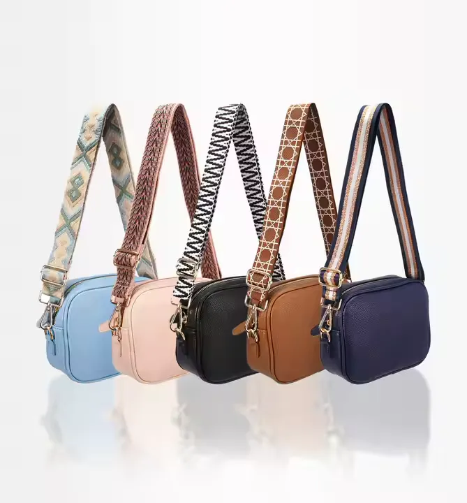 A collection of five small custom messenger bags in various colors—blue, pink, black, brown, and navy—each featuring a wide, patterned adjustable strap. The compact, rectangular design makes them ideal for casual outings or daily use.
