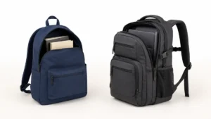 Side-by-side studio comparison of a lightweight muted-navy school bookbag with an open book compartment and simple front pocket, beside a structured charcoal backpack with multiple compartments, padded straps, chest strap, mesh bottle pocket, and visible laptop sleeve.